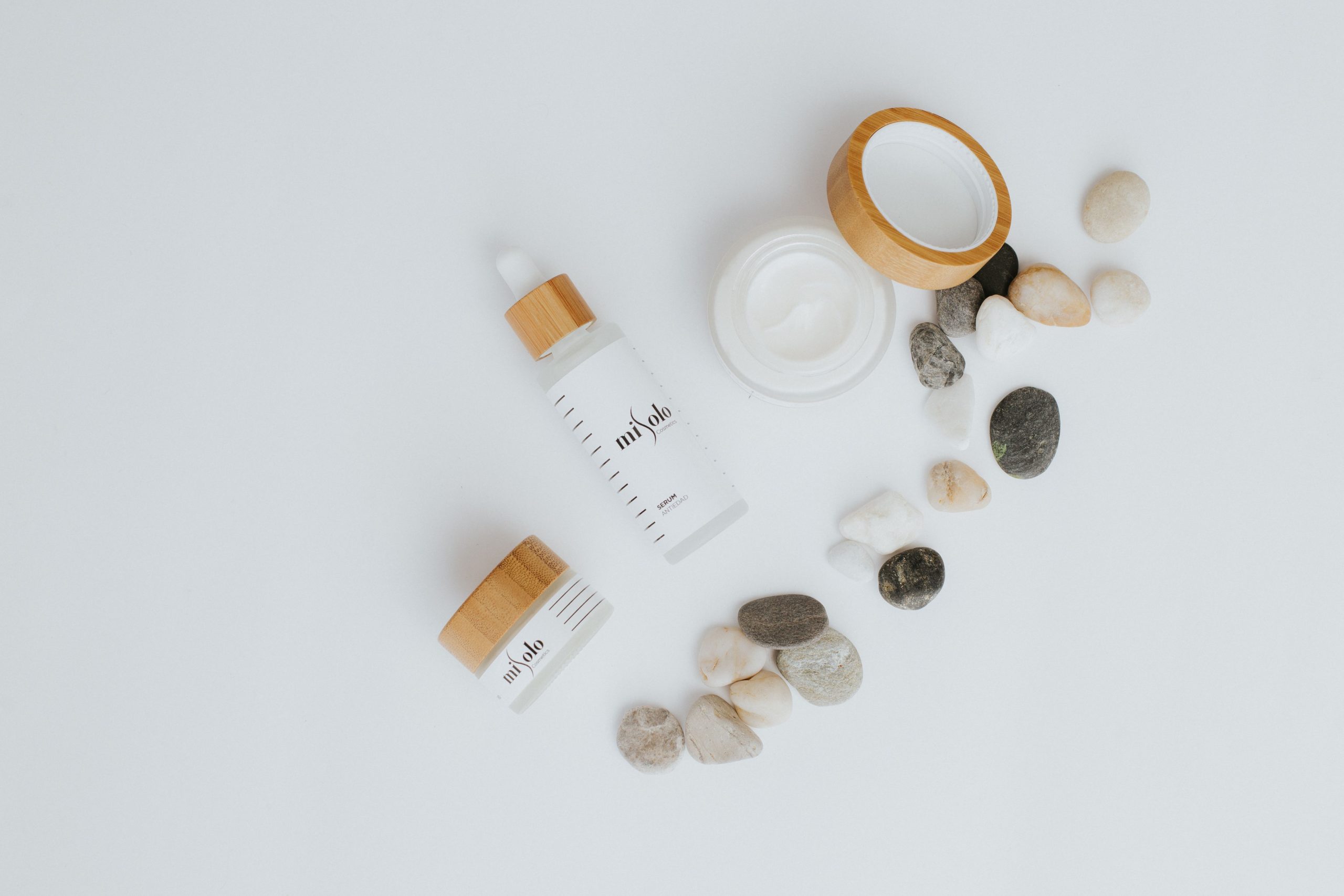 Flat lay de flacons de soin avec pierres blanches