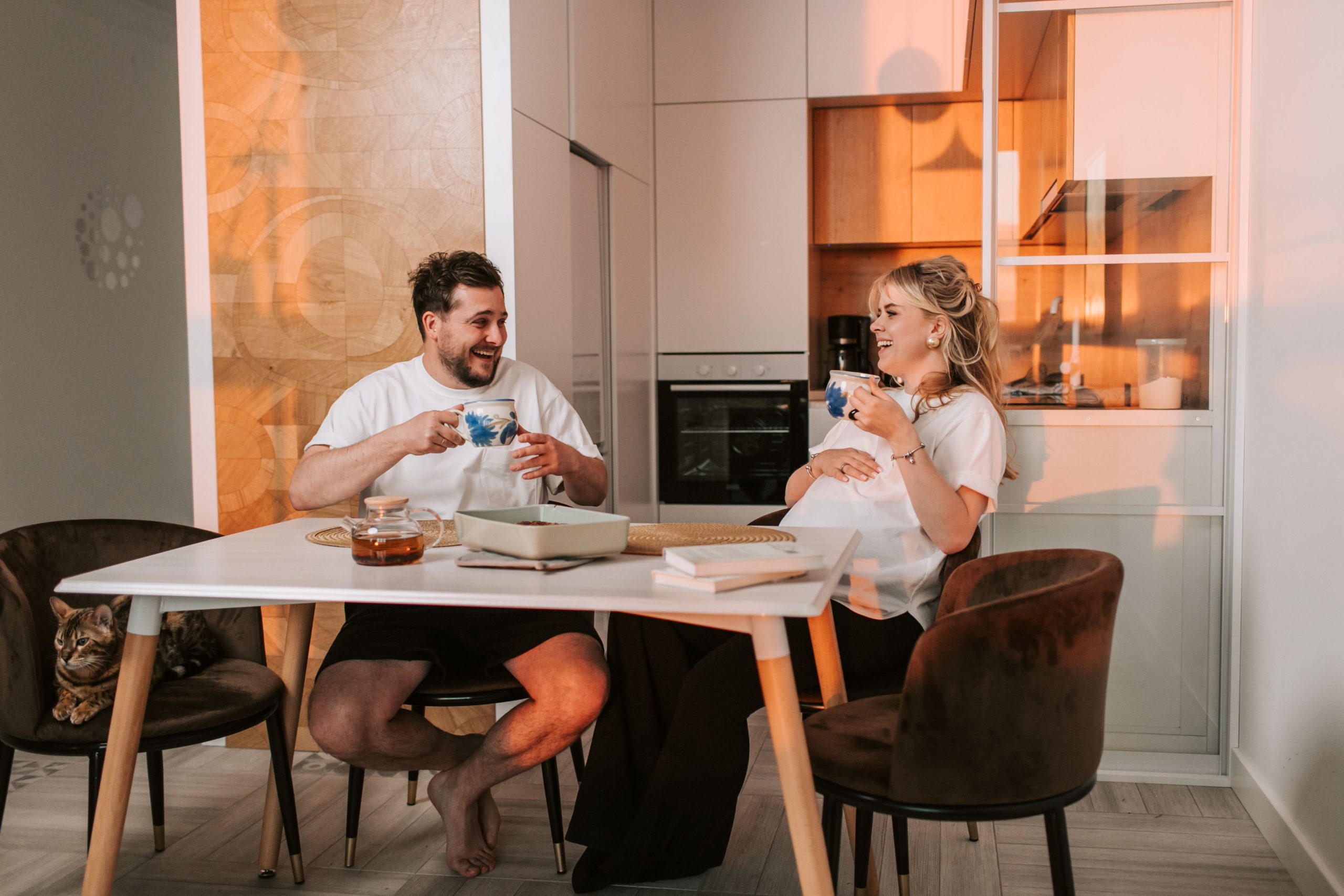 Couple heureux enceinte partageant thé en cuisine