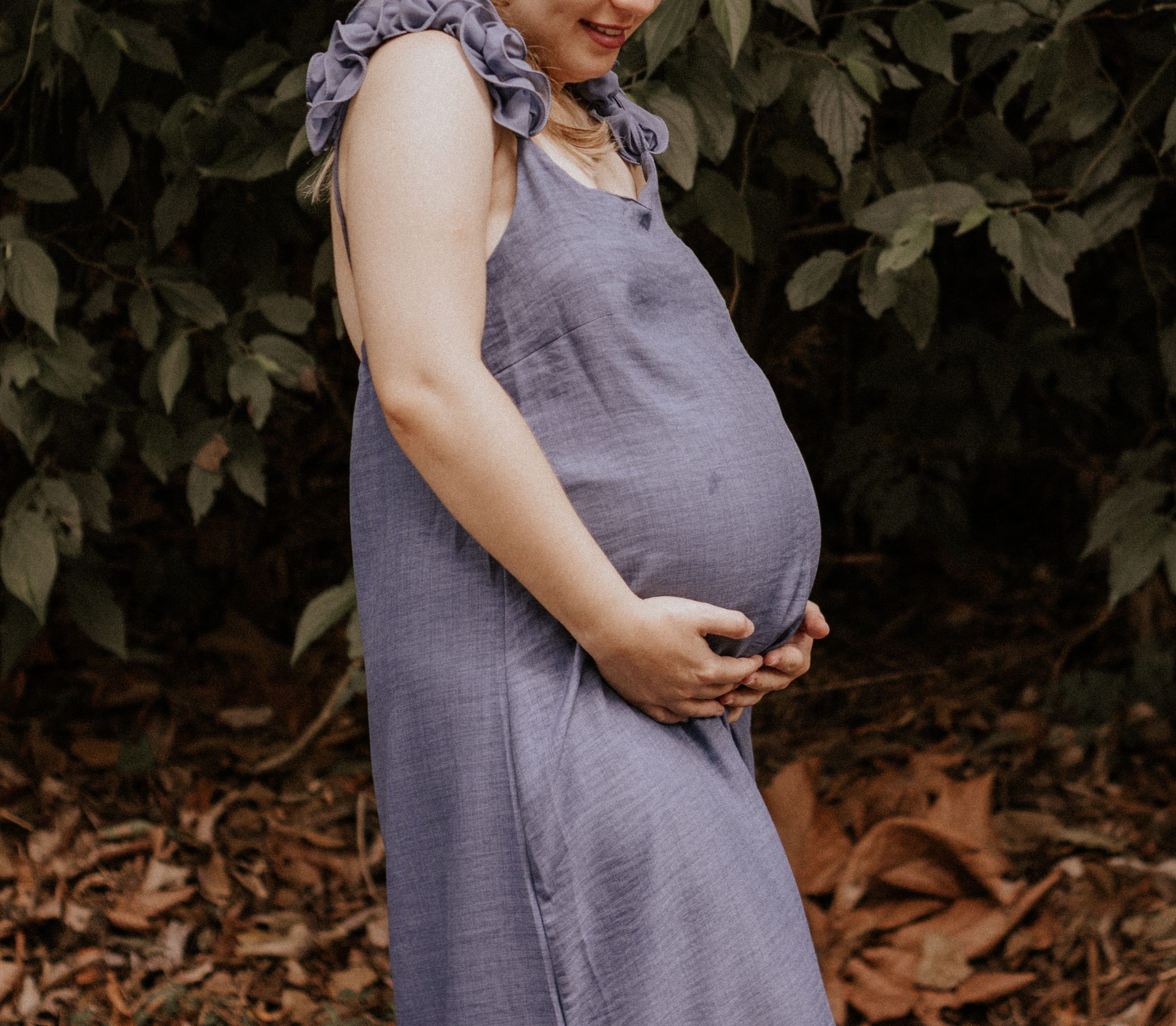 Femme enceinte en robe bleue profitant nature