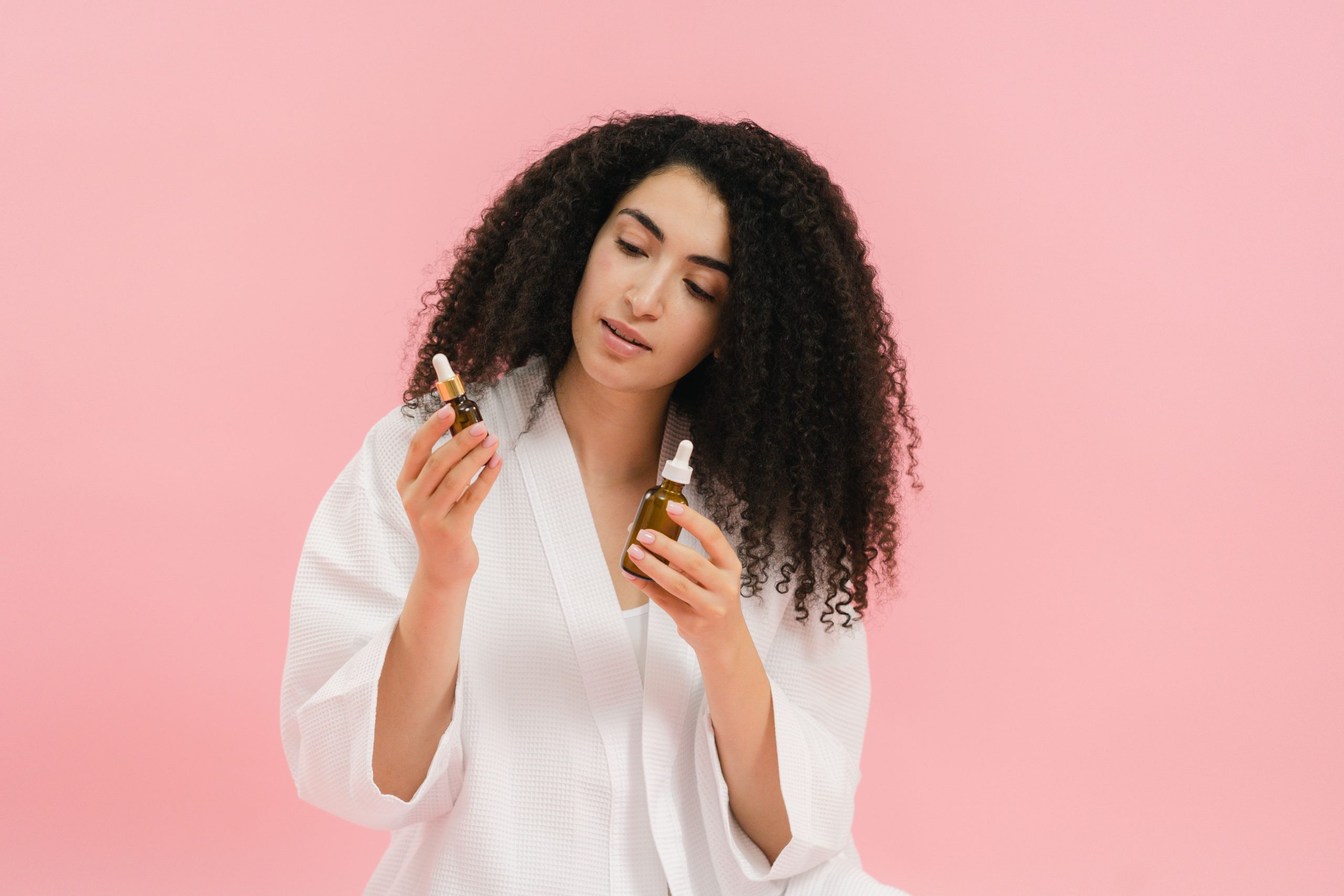 Femme examine deux bouteilles de soins cosmétiques liquides